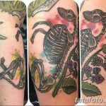 Фото тату: оригинальный рисунок, сочетающий в себе скелет животного, ветку с ягодами и цветы, выполненный в ярких и насыщенных цветах.