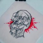 Эскиз татуировки с изображением лица, выполненного в геометрическом стиле. Сочетание острых углов, линий и красных акцентов.