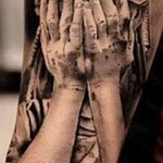 Фото тату на предплечье, изображающее руки Статуи Свободы, держащие факел, выполненное в реалистичном стиле с высокой детализацией.