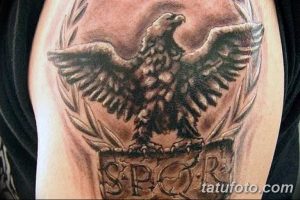 Фото тату на плече: Римский орел с расправленными крыльями и надписью SPQR на постаменте. Черно-серые тона, детализированный рисунок.