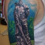 Фото тату солдата с пандoй на плече, выполненное в ярких цветах. Детализированный рисунок татуировки с изображением военной формы и милого животного.