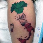 Фото тату на ноге с изображением карты Италии и надписей на латыни "Veni, Vidi, Vici". Реалистичный стиль, яркие цвета.