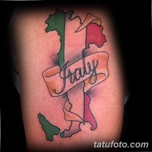 Фото тату карты Италии с надписью 'Italy' на плече. Цветной рисунок, реалистичное изображение карты, детализированная надпись.