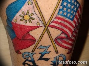 Фото тату: татуировка на руке с изображением флагов США и Филиппин, перекрещенных вместе с инициалами.