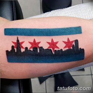 Фото тату: минималистичная татуировка на руке с изображением силуэта города Чикаго и четырех красных звезд.