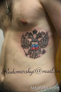 Фото тату на боку с изображением российского герба – двуглавого орла. Черно-белый рисунок, детализированная проработка, символ России.