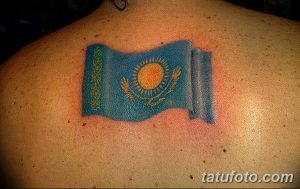 Фото тату на лопатке с изображением флага Казахстана. Яркий и детализированный рисунок национального символа.