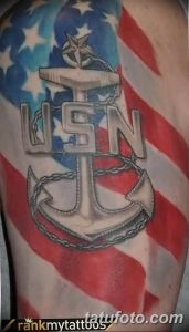 Фото тату на плече с изображением символики ВМС США: якорь, буквы USN и звезда. Патриотичный рисунок в черно-серых тонах.