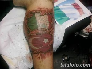 Фото тату, сочетающего в себе флаги Италии и Турции на руке. Изображение выполнено в ярких цветах с использованием красного, зеленого, белого и черного.