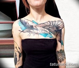Фото тату ворона на плече и груди, выполненного в технике blackwork с добавлением акварельных пятен голубого цвета.