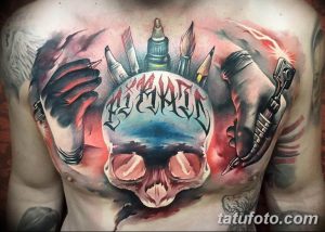Фото тату на груди и плечах, изображающее череп, окруженный кистями, красками и тату-машинками. Символизирует творчество и искусство.