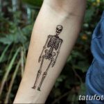 Фото тату с изображением минималистичного скелета, выполненного тонкими линиями, на предплечье. Простой и элегантный рисунок татуировки.