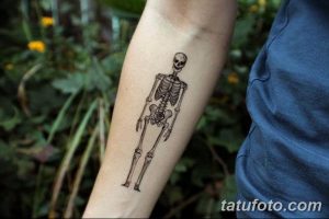 Фото тату с изображением минималистичного скелета, выполненного тонкими линиями, на предплечье. Простой и элегантный рисунок татуировки.
