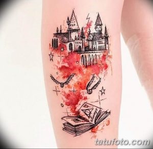 Фото тату на ноге с изображением Хогвартса, снитча и книги заклинаний из мира Гарри Поттера. Рисунок выполнен в стиле акварели.
