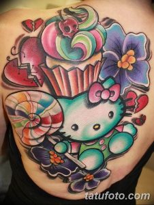 Фото татуировки на теле: Hello Kitty с разбитым сердцем, окруженная цветами и яркими элементами в стиле old school.