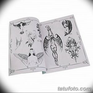 Фотография страницы альбома с различными эскизами татуировок с изображением ангельских крыльев. Разнообразие стилей и дизайнов.