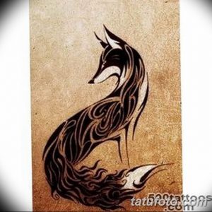 Черно-белая татуировка лисы, выполненная в стиле племенного орнамента с использованием завитков и узоров. Изысканный и стильный дизайн.