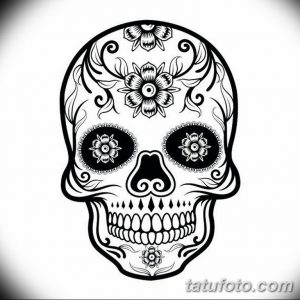 Фото тату черепа в стиле сахарной смерти (Calavera), украшенного цветочными узорами и геометрическими фигурами. Черно-белый рисунок.