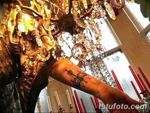 Фото тату на руке: стилизованный ключ и канделябр, выполненные в темных тонах. Оригинальный эскиз татуировки с символическим значением.