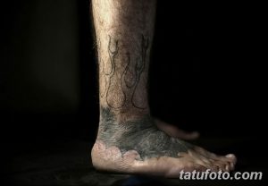 Фото тату: Татуировка в виде языков пламени, обвивающих лодыжку и переходящих на стопу. Темные оттенки и четкие линии.