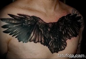 Фото татуировки с изображением ворона, раскинувшего крылья на груди. Мощный и впечатляющий рисунок, выполненный в реалистичном стиле.