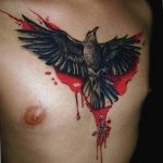 Фото тату ворона с красными брызгами на груди. Черно-красный рисунок татуировки в стиле акварель, выполненный опытным мастером тату.