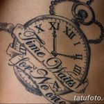 Черно-серое фото татуировки карманных часов с цепью и надписью 'Time waits for no one' на боку.
