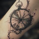 Фото тату на руке: карманные часы в стиле скетч с брызгами краски. Черно-белая татуировка с эффектом незаконченного рисунка.