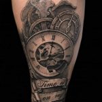 Фото тату на руке: механизм часов с надписью "Time is on my side". Черно-серый рисунок в стиле реализм.