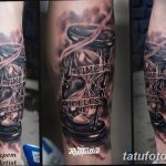Фото тату на руке: песочные часы с надписью "Time is priceless". Реалистичный черно-серый рисунок с эффектом объема.