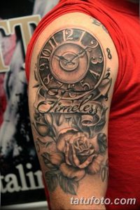 Фото тату на руке: карманные часы, розы и надпись "Timeless" в черно-белом стиле.