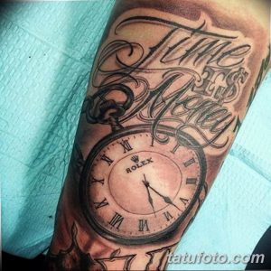 Фото татуировки на руке с изображением часов Rolex и надписью 'Time is Money'. Детализированный рисунок в стиле реализм.