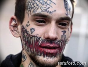 Фото тату: экстремальная татуировка на лице, включающая оскал с острыми зубами, надписи 'Old School' и другие элементы. Провокационный и запоминающийся эскиз тату.
