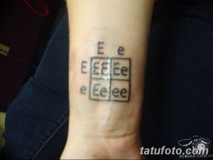 Фото тату на руке: квадрат, заполненный различными буквами "E" и "e" в хаотичном порядке. Минималистичный черно-белый рисунок татуировки.