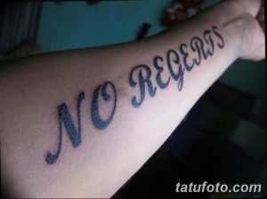 Фото тату на руке: надпись 'No Regrets' выполненная курсивным шрифтом, символизирующая свободу и отсутствие сожалений.