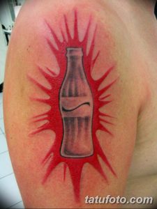 Яркая татуировка на плече с изображением бутылки Coca-Cola, из которой вырываются красные брызги. Динамичный и оригинальный дизайн.