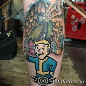 Фото тату на предплечье с изображением главного героя игры Fallout и постапокалиптического пейзажа. Яркие цвета и детализированная проработка.
