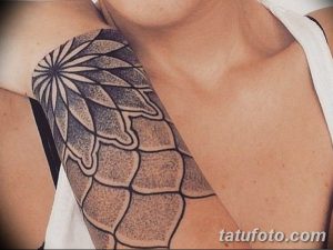 Фото тату: абстрактная татуировка на груди, выполненная в технике дотворк, с использованием геометрических фигур и точек.