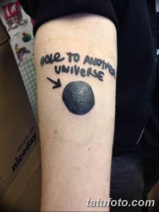 Фото тату на руке: черная дыра с надписью "HOLE TO ANOTHER UNIVERSE", выполненная в минималистичном стиле. Оригинальный эскиз татуировки.