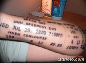Фото тату на руке: точная копия билета на концерт Green Day от 29 июля 2009 года. Детализированный рисунок татуировки, имитирующий бумажный билет.