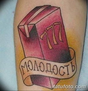 Фото тату с изображением книги с надписью "177" и "Молодость", выполненное в ярких, но немного выцветших цветах. Ностальгический и символичный выбор.