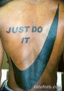 Фото тату на спине мужчины с надписью 'Just Do It' и логотипом Nike в виде галочки. Черно-серая татуировка, вдохновленная спортивным брендом.