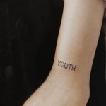 Фото тату надписи "YOUTH" на внутренней стороне предплечья. Черный цвет, простой шрифт.