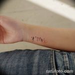 Фото тату схематичных фигурок людей на запястье. Черный цвет, тонкие линии.
