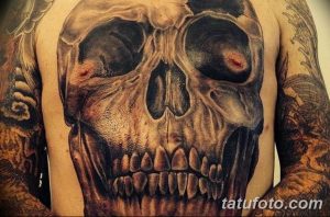Большая, реалистичная татуировка черепа, покрывающая грудь и плечи. Детализированный рисунок с тенями и текстурами.