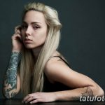 Фото тату на руке девушки: реалистичные розы в черно-серых тонах, детальная проработка лепестков и листьев, элегантный дизайн.