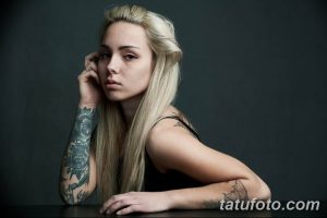 Фото тату на руке девушки: реалистичные розы в черно-серых тонах, детальная проработка лепестков и листьев, элегантный дизайн.