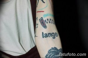 Фото тату на предплечье: надпись 'lange' и схематичный рисунок, напоминающий палец, держащий предмет.