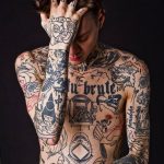 Фото татуированного тела мужчины с полностью покрытыми татуировками руками и спиной. Разнообразные рисунки в стиле олд скул и традиционной татуировки.