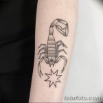 Фото тату: Лаконичный рисунок скорпиона, выполненный в технике blackwork. Татуировка украшает предплечье и включает в себя стилизованное изображение звезды.